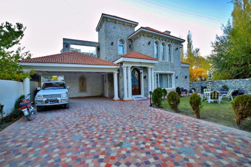 un coche aparcado frente a una casa en Arish Luxury Suites, en Skardu