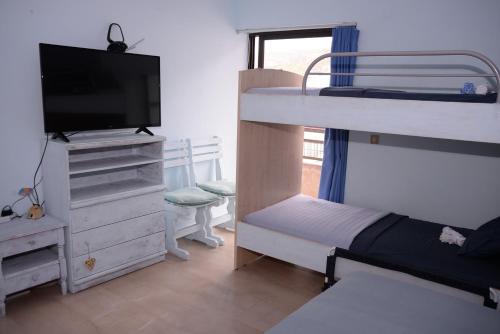 a bedroom with two bunk beds and a flat screen tv at Dream house in Loutraki