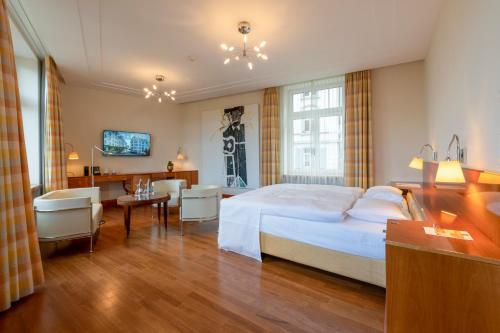 ザンクト・ガレンにあるアインシュタイン ザンクト ガレンのベッドとデスクが備わるホテルルームと