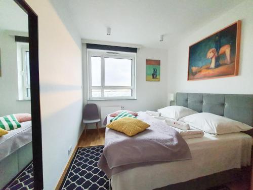 1 dormitorio con cama y espejo en Capital Apartments - Towarowa, en Poznan