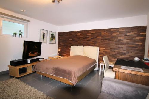 a bedroom with a bed and a desk and a television at Großes Privatzimmer in Messenähe in Hannover