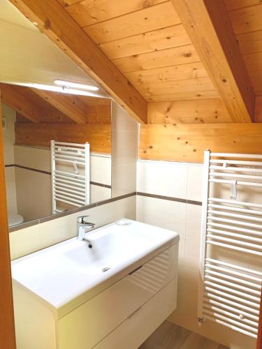 a bathroom with a white sink and a mirror at Villa Marilyn in Ledro