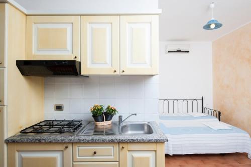 a kitchen with a sink and a bed at Residence S'incantu in Villasimius