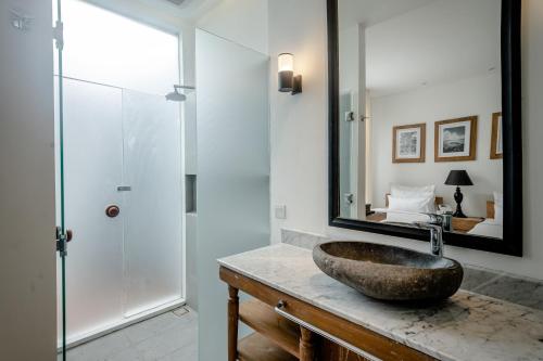 Un baño con un lavabo y un espejo sobre un mostrador. en Gioheven Villa, en Nusa Dua