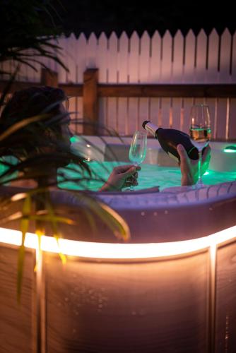 two people holding wine glasses in a swimming pool at night at Slottshotellet in Kalmar