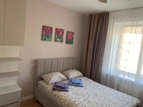 1 dormitorio con 1 cama con 2 toallas en Квартира в новобудові в районі автовокзал , поруч ТРЦ Арена, en Rivne