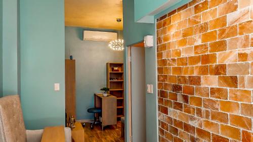 a living room with a brick wall and a chair at Urban Oasis Aparthotel in Cape Town