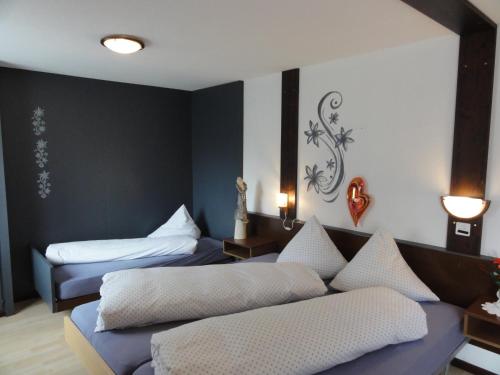 a hotel room with two beds and a couch at Hotel Primavera in Saas-Grund