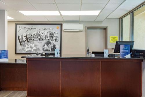 an office cubicle with a reception counter with a desk at Super 8 by Wyndham Melbourne in Melbourne