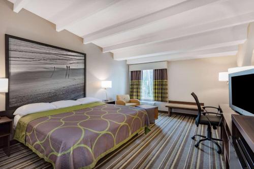 a hotel room with a bed and a flat screen tv at Super 8 by Wyndham Melbourne in Melbourne