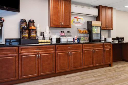 a kitchen with wooden cabinets and a counter top at Super 8 by Wyndham Melbourne in Melbourne