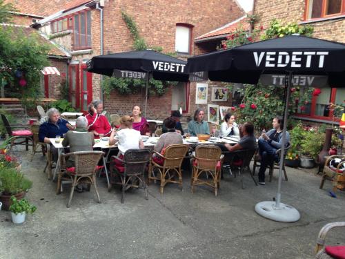 a group of people sitting at a table under an umbrella at B&B De Henehoeve in Heks