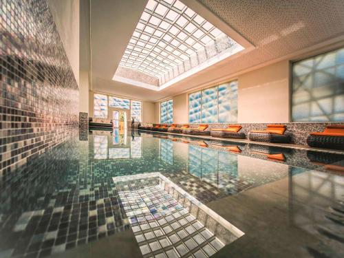 una gran piscina con techo de cristal en Sofitel Rabat Jardin Des Roses en Rabat