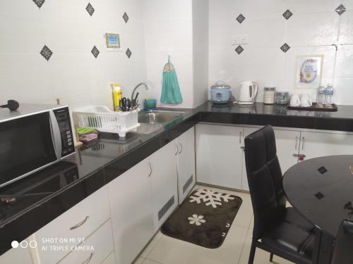 a kitchen with a sink and a microwave at DPerdana -Dinies pool,wifi, centre of Kota Bharu, 4-5 pax in Kota Bharu