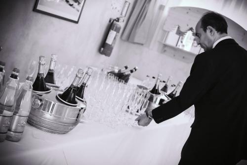 a man standing in front of a bar with wine glasses at Hotel Rivè - Complesso Turistico Campo Smith in Bardonecchia