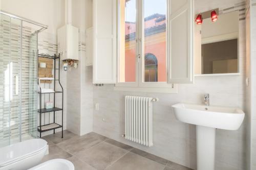 ボローニャにあるResidence del Professore by Studio Vitaのバスルーム(洗面台、トイレ付)、窓が備わります。