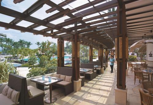 
a patio area with tables, chairs, and tables with umbrellas at Shangri-La Rasa Sentosa, Singapore (SG Clean) in Singapore
