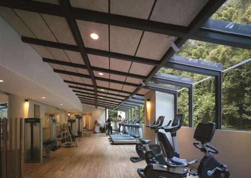 a gym with a row of exercise equipment and windows at Shangri-La Rasa Sentosa, Singapore in Singapore