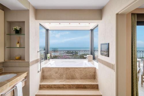 a bath tub in a bathroom with a large window at Shangri-La Rasa Sentosa, Singapore in Singapore