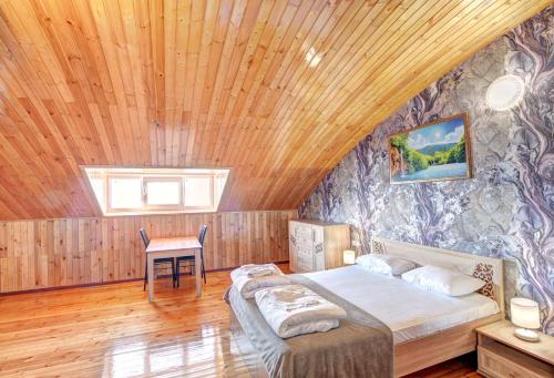 a bedroom with a bed and a wooden ceiling at Son y Morya in Sochi