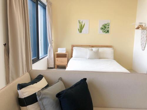 a bedroom with a bed and a couch with pillows at Tropicana 218 Macalister Netflix Seaview in George Town