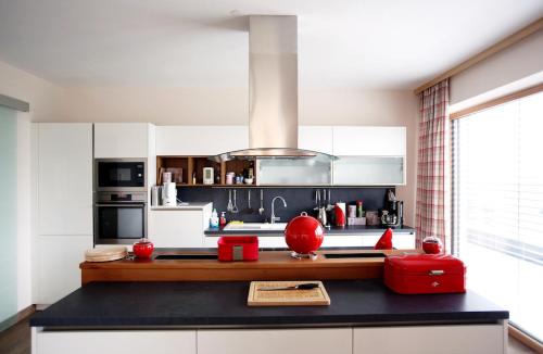 una cocina con encimera negra y un aparato rojo en Haus Clarysse en Schladming