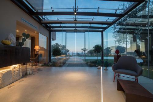 a lobby with a chair and a room with windows at Best Western Plus Hotel Terre di Eolo in Patti