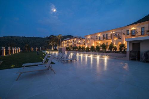 a building with benches in front of it at night at Best Western Plus Hotel Terre di Eolo in Patti