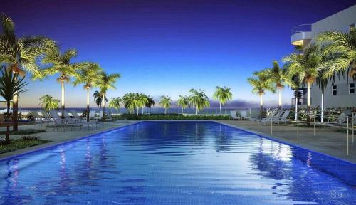帕奈米林的住宿－Resort In Mare Bali - Apto lado da sombra，一座大型游泳池,在一座建筑前种有棕榈树