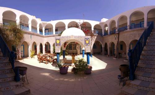 an open courtyard with tables and chairs in a building at Hôtel Sindbad in Houmt Souk