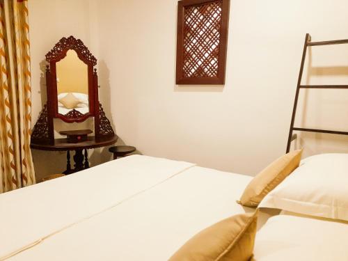 a bedroom with a bed and a mirror at Halcyon Rest in Hikkaduwa