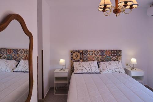 1 dormitorio con 2 camas y lámpara de araña en Casa Marisa Sancti Petri, en Novo Sancti Petri