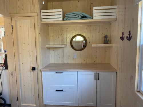 a small bathroom with white cabinets and a mirror at Chalets Memphrémagog in Magog-Orford