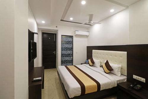 1 dormitorio con 1 cama grande y TV en Silver Shine New Delhi - COMFORT STAY, en Nueva Delhi