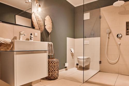 a bathroom with a shower and a toilet and a sink at Luxus Ferienwohnung Beach Style, traumhafter Seeblick in Fulda
