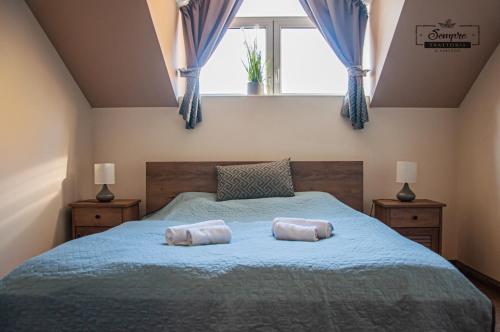 a bedroom with a bed with two pillows on it at Sempre Étterem És Panzió in Székesfehérvár