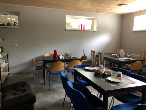 a dining room with tables and chairs and a window at Metsalagendik in Otepää
