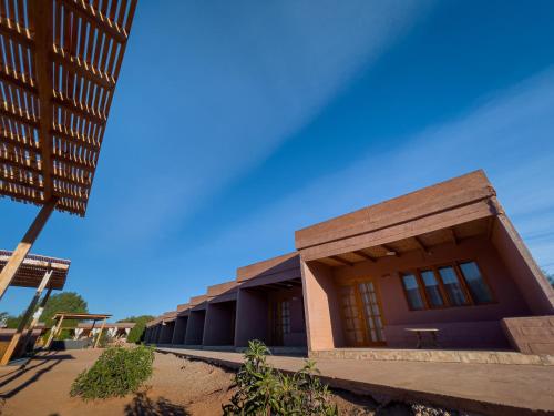 a school building with a blue sky in the background at Ittai Hotel in San Pedro de Atacama