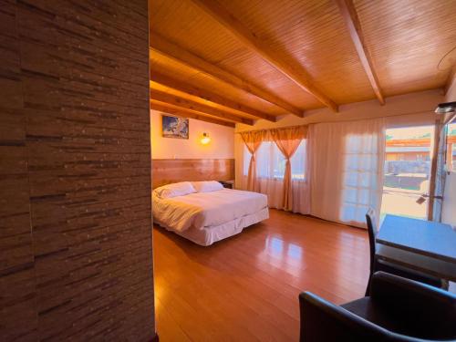 a bedroom with a bed and a table in a room at Ittai Hotel in San Pedro de Atacama