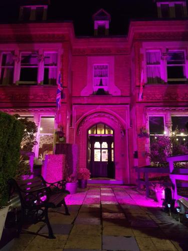 a pink lighting up the front of a building at The Lismore Hotel in Banbury