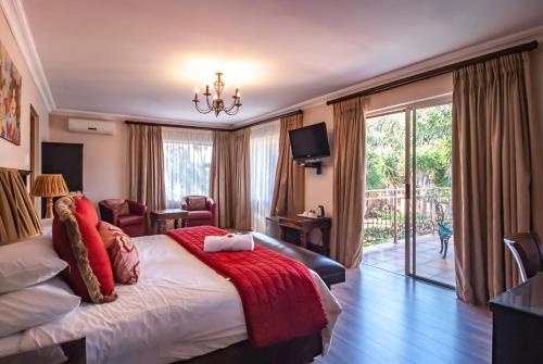 1 dormitorio con 1 cama grande con manta roja en Sunward Park Guest House & Conference Center, en Boksburg