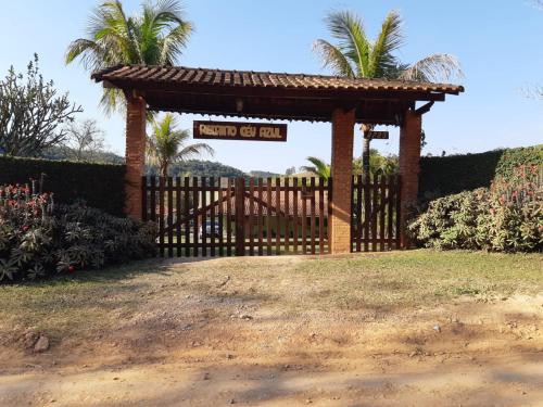 a gate with a sign that reads death coil inn at Casa de Campo "Recanto Céu Azul" in Guararema