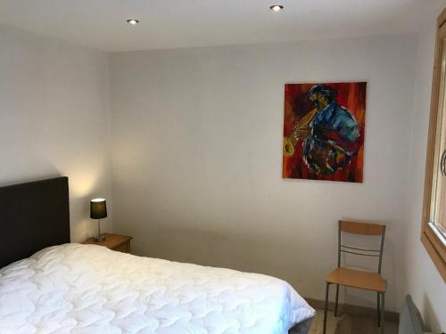 モンジェネヴルにあるAppartement Montgenèvre, 2 pièces, 6 personnes - FR-1-445-34のベッドルーム1室(ベッド1台付)が備わります。壁には絵画が飾られています。