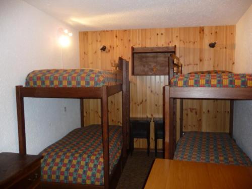 モンジェネヴルにあるAppartement Montgenèvre, 3 pièces, 6 personnes - FR-1-445-104の木製の壁の客室で、二段ベッド2組が備わります。