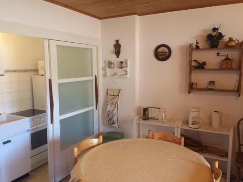 Studio Montgenèvre, 1 pièce, 4 personnes - FR-1-445-90 في مونجينيفر: مطبخ مع طاولة ومطبخ صغير مع كونتر