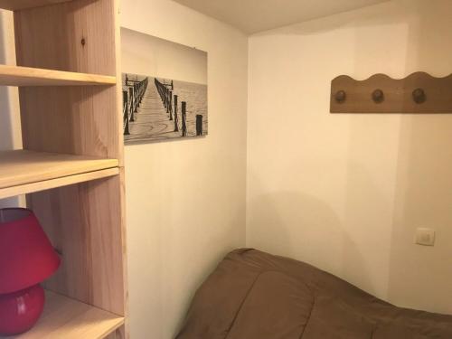 um pequeno quarto com uma cama e uma prateleira em Studio Montgenèvre, 1 pièce, 3 personnes - FR-1-445-137 em Montgenèvre