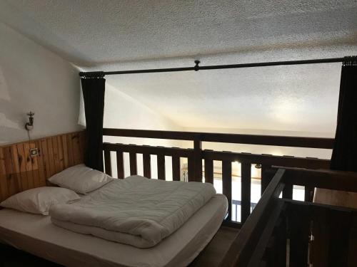 Bett in einem Zimmer mit einem großen Fenster in der Unterkunft Appartement Montgenèvre, 2 pièces, 6 personnes - FR-1-445-94 in Montgenèvre