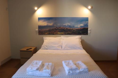 a bedroom with a bed with two towels on it at Altitude Alojamento e Restauração in Belmonte