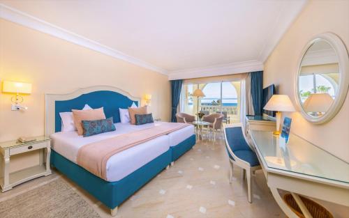 a hotel room with a bed and a table and chairs at Steigenberger Marhaba Thalasso Hammamet in Hammamet