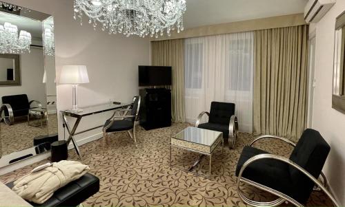 a living room with a table and chairs and a desk at Hotel Adriatica in Geneva